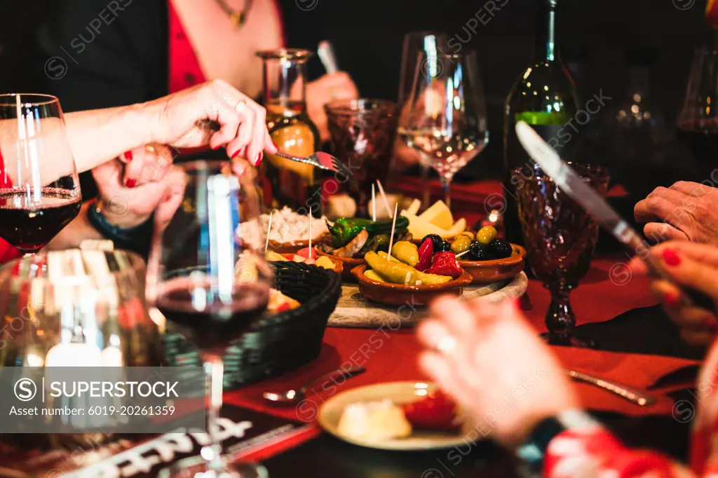 People eating Tapas at a Tapas Bar with food and drinks on the table