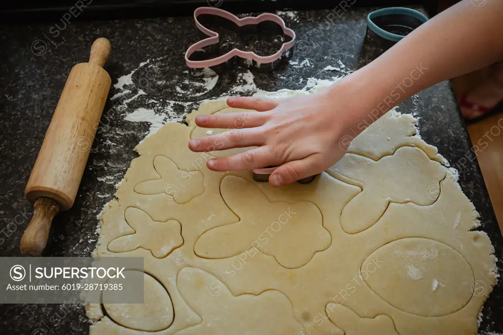 Person preparing Easter shaped cookies