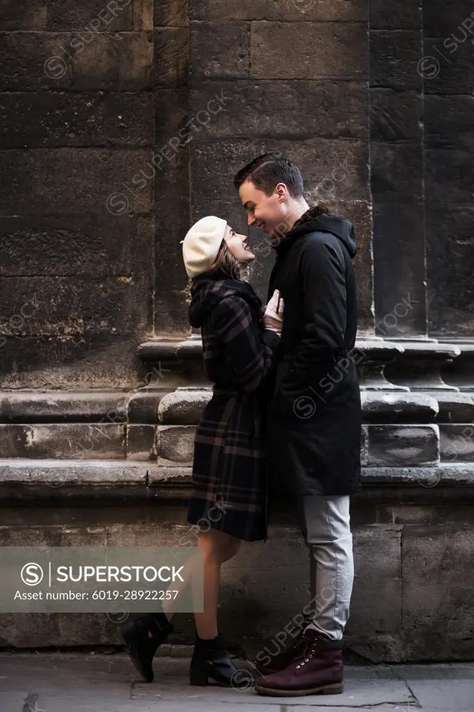 young man and woman laughing on the autumn streets of a European city