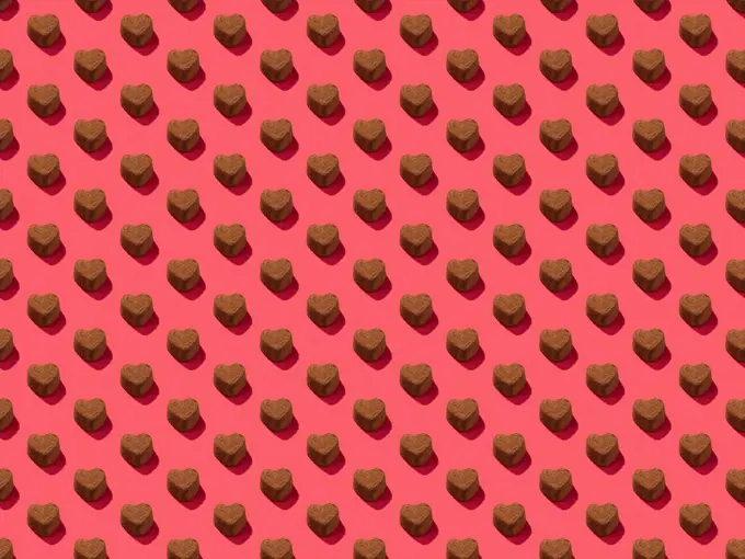 chocolate heart candy on a pink background pattern