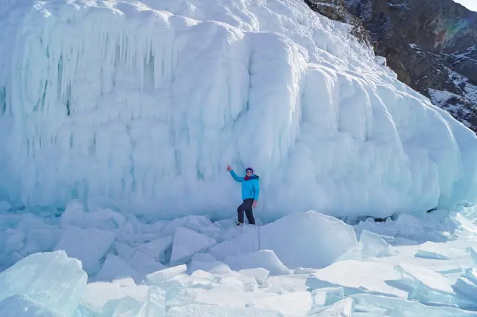 A woman of 35-40 years old stands on the background of the icy