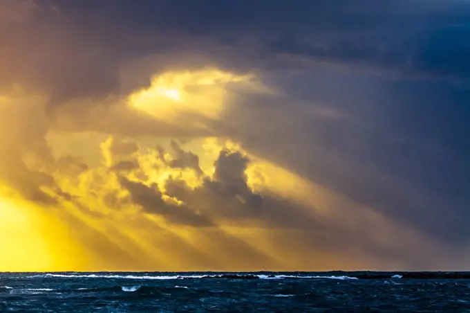 Sun rays from the sky over the sea at sunset