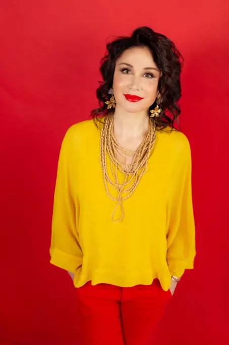 Young woman in yellow blouse on red background