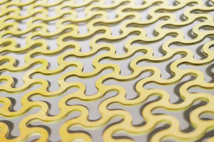 Abstract background, a repeating pattern of gold curved round cells in a gold lattice.