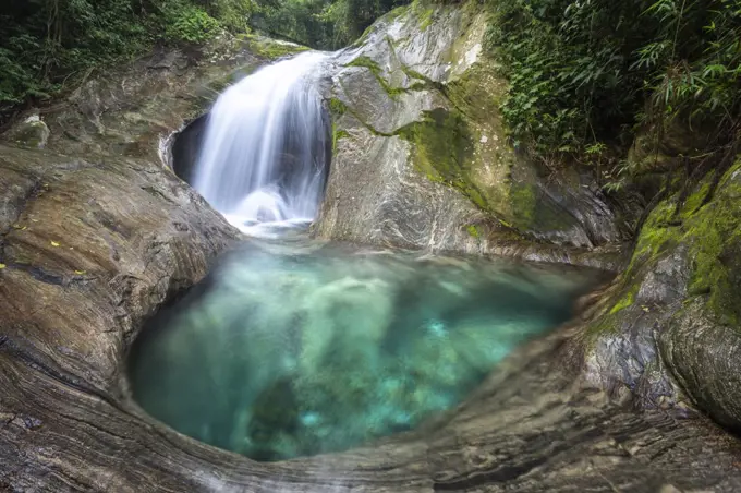 Beautiful green rainforest waterfall with crystal clear water pool