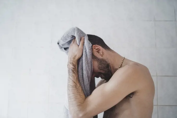 close up white man drying himself at home in his bathroom