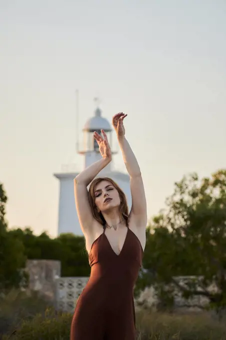 Young woman poses in a maroon dress at the Santa Pola Lighthouse