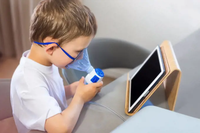 Nebulizer. The boy breathes through the mask.