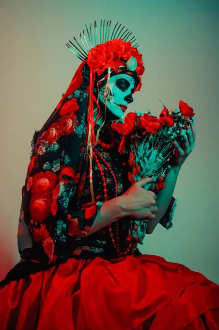 Young woman in calavera style with Mexican skull make-up on her face