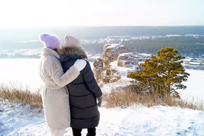 Women hugging each other stand in front of White Rocks