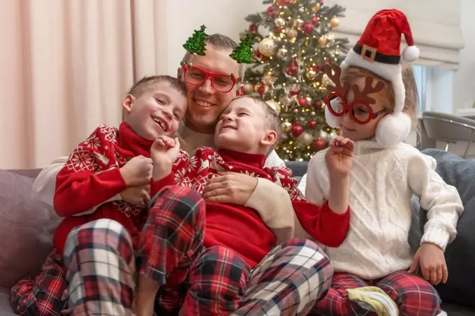 dad and kids at christmas time playing on the couch