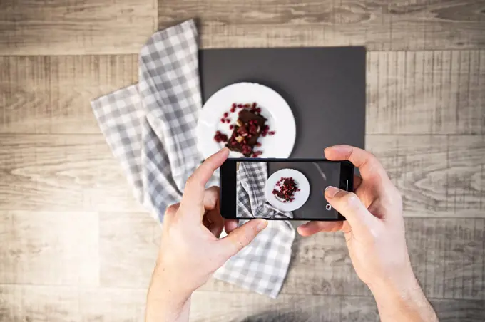 Man taking food photo using smartphone