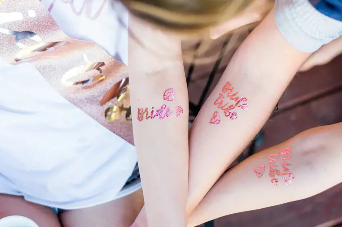 Girls at a bachelorette party with bride tribe tatoos.