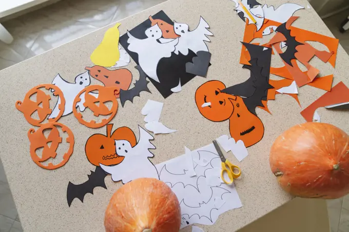 Crafts made of colored paper and pumpkins for Halloween.