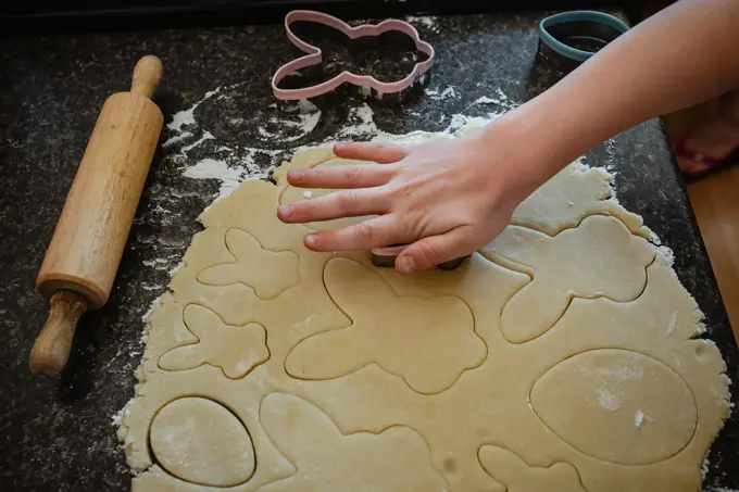 Person preparing Easter shaped cookies