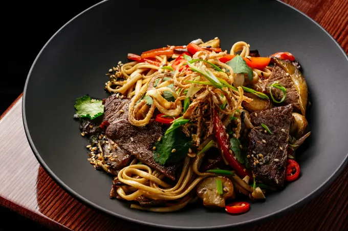 asian noodles with beef and vegetables. restaurant menu