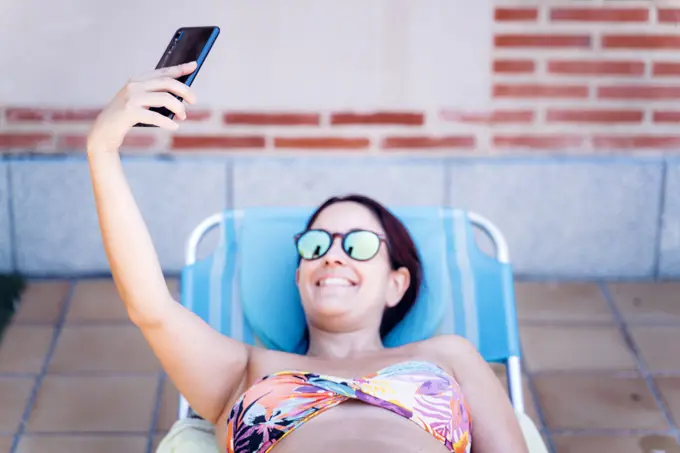 attractive young woman taking a selfie with her smartphone on vacation