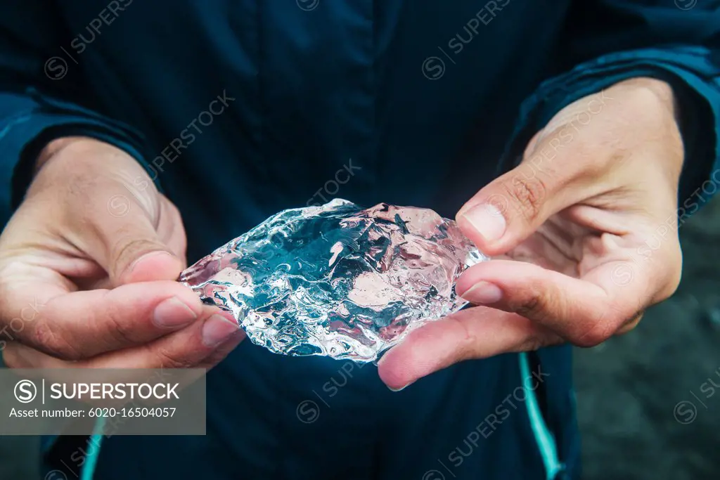 Hands holding an piece of ice broken off from a glacier, glacier lagoon in jokulsarlon, jökulsarlon Iceland, Scandinavia, Europe