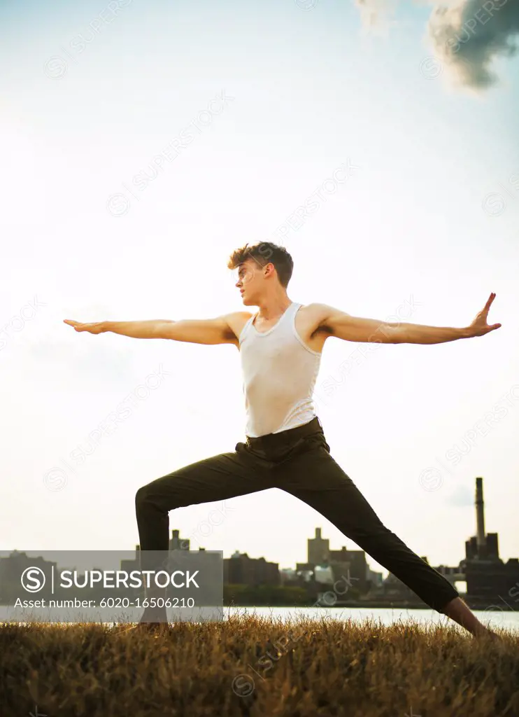 young man doing yoga in the park