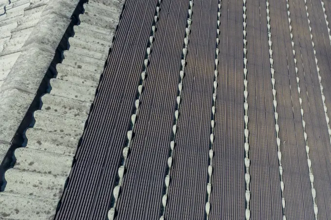 Aerial view of swimming pool solar heating tubes on a green tiled roof