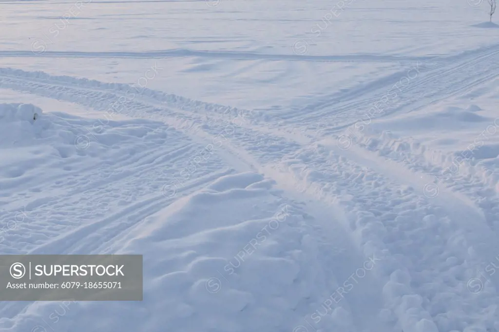 Abstract shot of tracks in snow at sunrise. Winter scene in Swedish Lapland