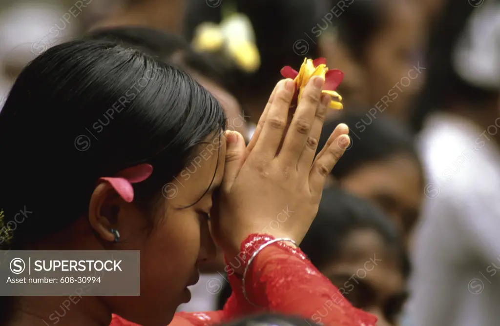 Close-up of a young woman praying in a temple, Ubud, Bali, Indonesia