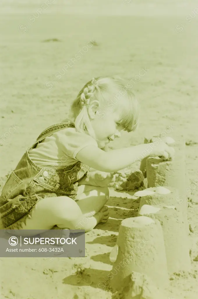 Side profile of a girl making a sand castle on the beach