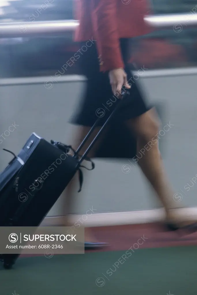 Side profile of a woman pulling luggage