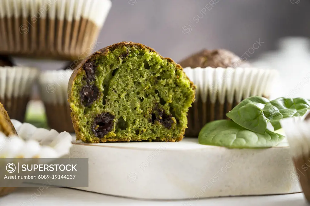 Spinach muffins. Half of a green muffin with fresh spinach leaves. Home bakings