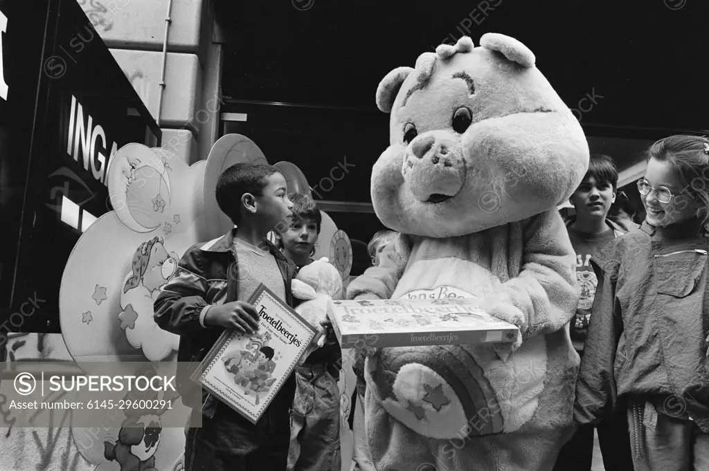 Anefo photo collection. 100,000th visitor film "Care bears", Mervin van der Kruys (L) gifts Care Bear Bioscoop Alfa cinema. 14, 1986. Amsterdam, Noord-Holland