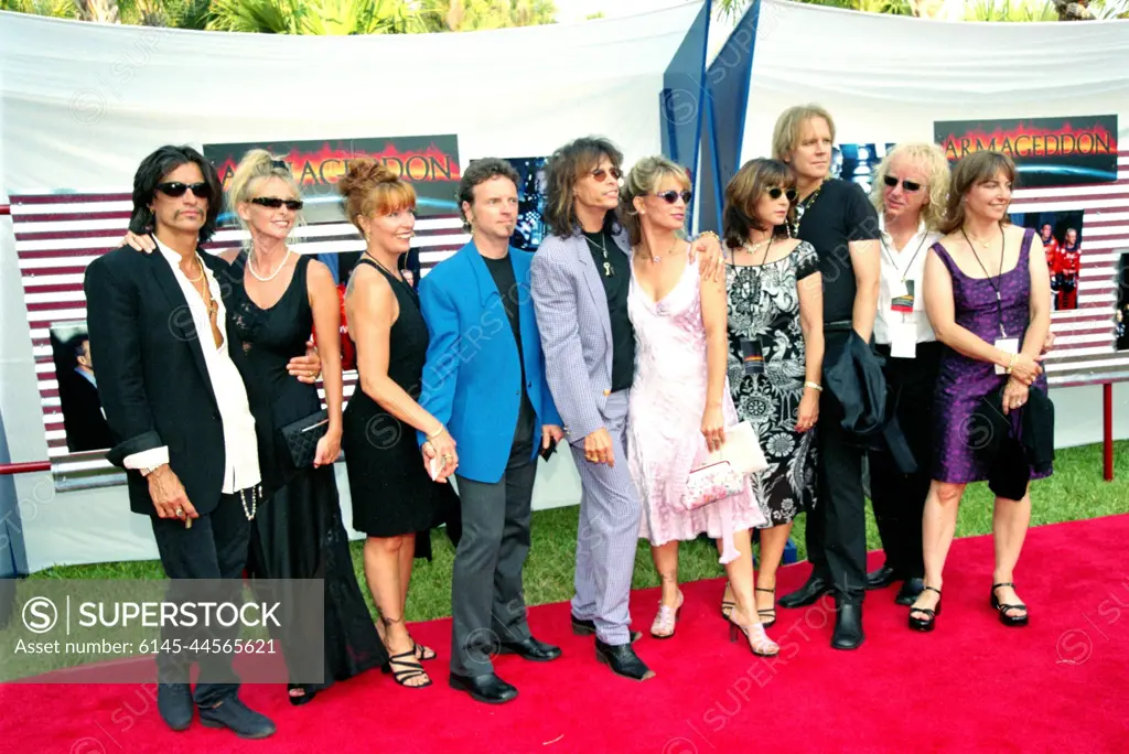 KENNEDY SPACE CENTER, FLA. --  The rock band Aerosmith, with their guests, stop on the red carpet entrance to the site of the world premiere of the movie "Armageddon," which was held at the Kennedy Space Center in Florida.  A special theater was constructed for the premiere outside the Apollo/Saturn V Center.  The band, which provided four songs for the film's soundtrack, performed at a private party on the site after the screening.  Lead vocalist Steve Tyler (middle) is the father of one of the stars of the movie, Liv Tyler.  The movie was partly filmed at KSC, and as part of the premiere festivities, guests had a chance to see many of the sites actually used in the film as well as explore a wide range of NASA artifacts and displays.