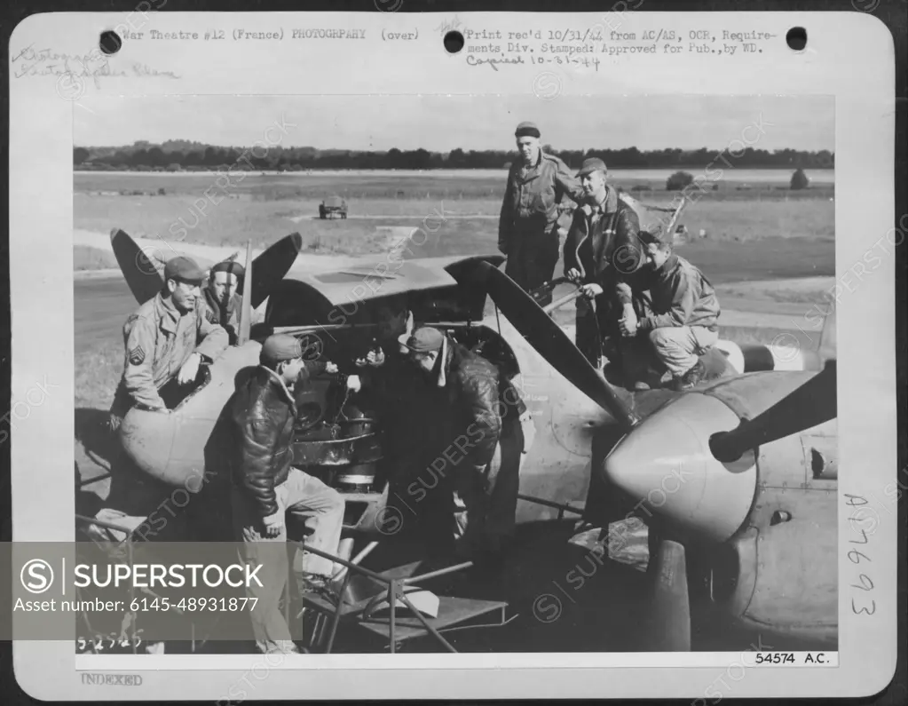 First pictures of the Allied landings in France are being removed from Lockheed P-38 Lightning camera plane (F-5) after Lt. Col. C.A. Shoop returned from photo reconnaissance flight over the landing beaches on D-Day.
