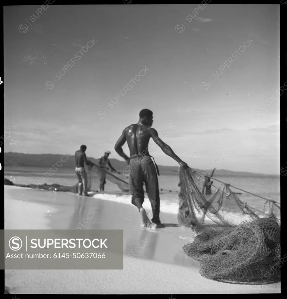 Men on beach with fishing net, Montego Bay, Jamaica, Toni Frissell
