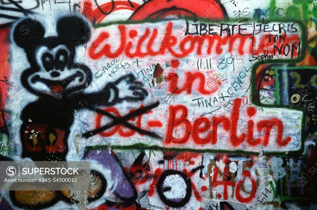 Graffiti on the west side of the Berlin Wall depicts the transition toward a unified Berlin. Base: Berlin Country: Deutschland / Germany (DEU)