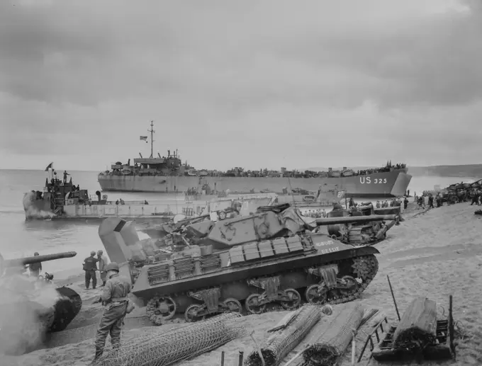 Photograph of Medium Tanks Unloading with LCT-153 and LST-325 in BackgroundArmy men loading landing craft with food supplies at an English port, in preparation for France invasion. Medium tanks unloading with LCT-153 and LST 325 in background. Pre D-day. 1943 - 1968.