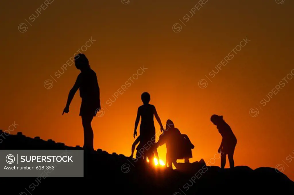 USA, California, Los Angeles, Dockweiler Beach, People silhouetted against setting sun
