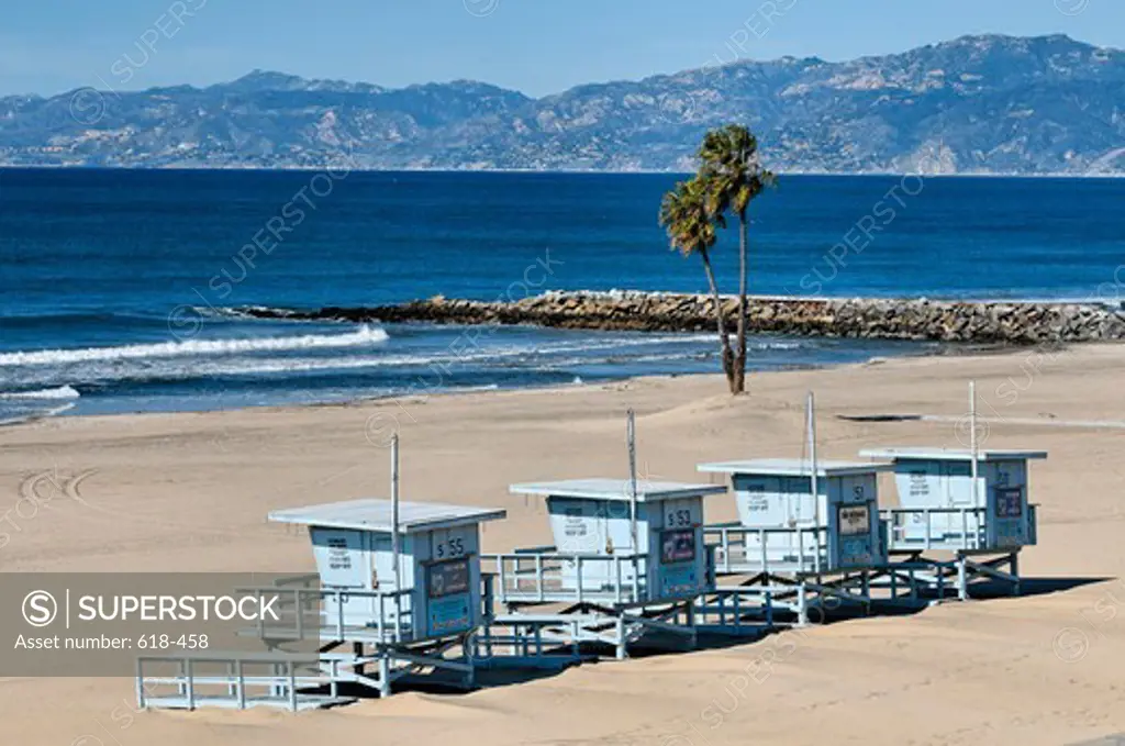 USA, California, Los Angeles, Westchester, Four lifeguard platforms gathered together on Dockweiler Beach during winter season, In distance Santa Monica Mountains rising above Santa Monica Bay as seen on clear winter day