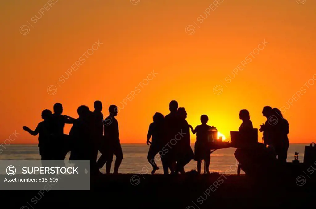 USA, California, Los Angeles, Westchester, Santa Monica Bay, People dancing and celebrating on beach at sunset