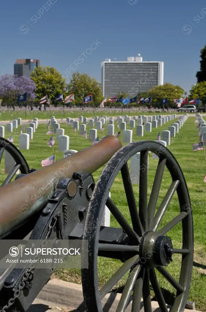 Cannon in a cemetery with a government building in the background, Westwood Federal, Los Angeles National Cemetery, Los Angeles, California, USA