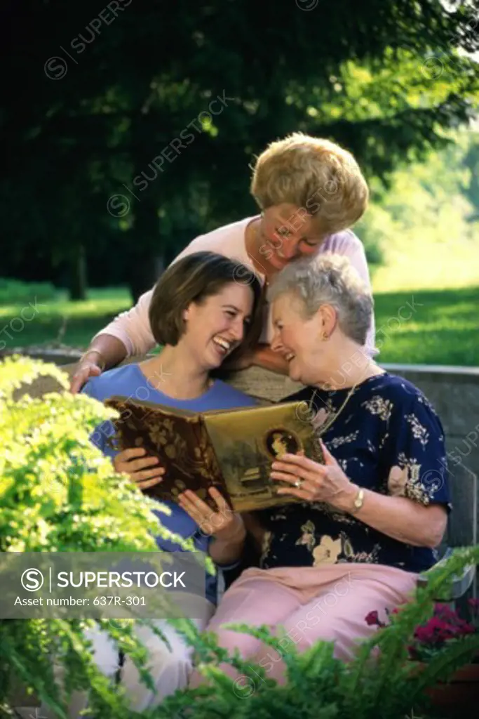Daughter sitting in a park with her mother and grandmother
