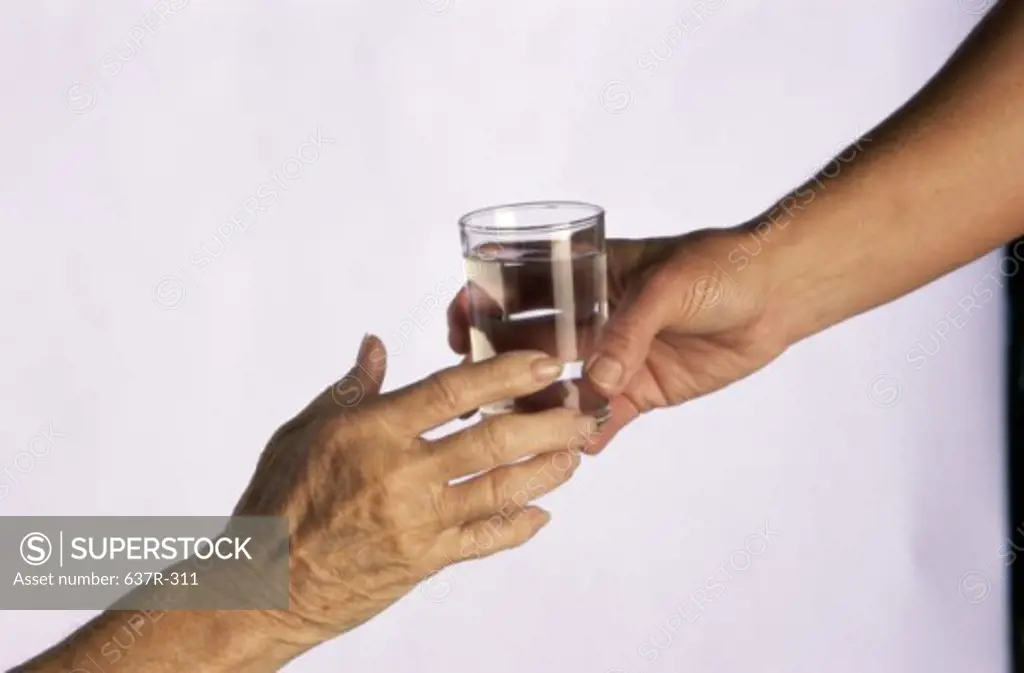 Person handing another person a glass of water