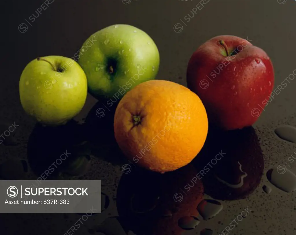 Close-up of apples and an orange