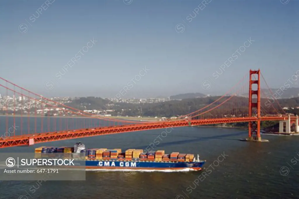 High angle view of a container ship passing under a suspension bridge, Golden Gate Bridge, San Francisco, California, USA