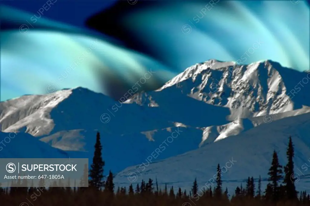 Aurora borealis over snow covered mountains, Alaska, USA