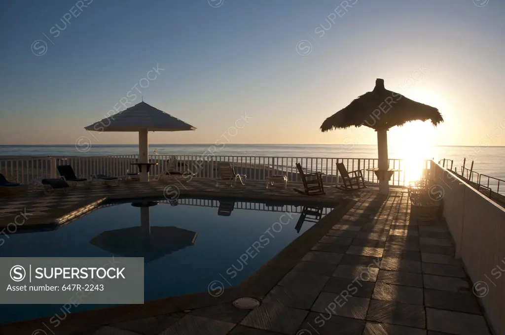 Mexico, Baja California Sur, Los Barriles, swimming pool and sea at sunset