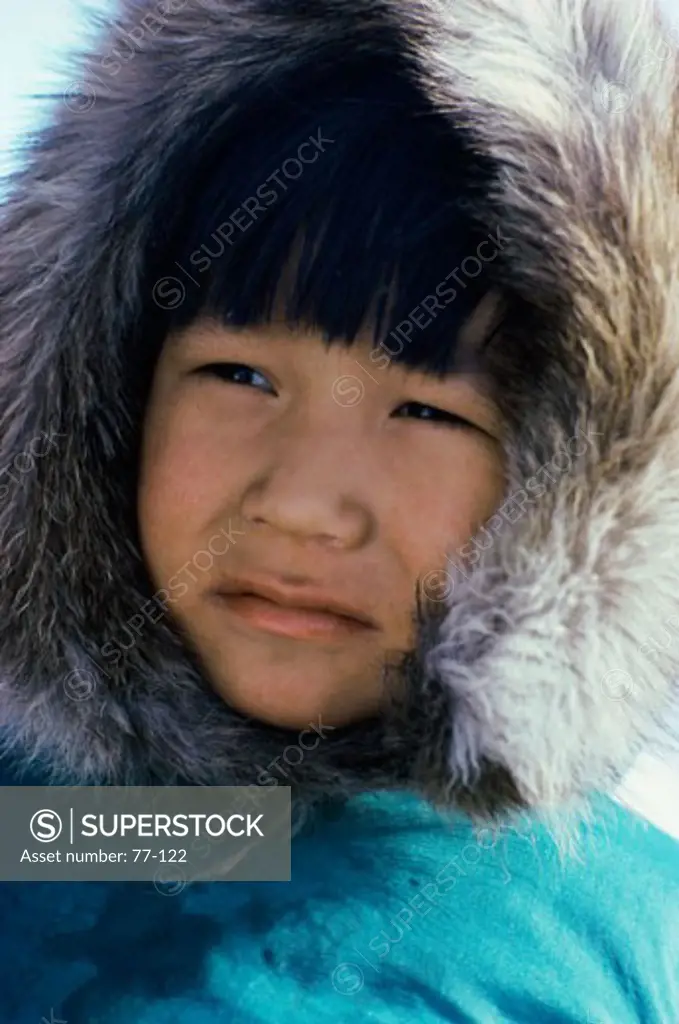 Inuit boy in a traditional Parka looking sideways