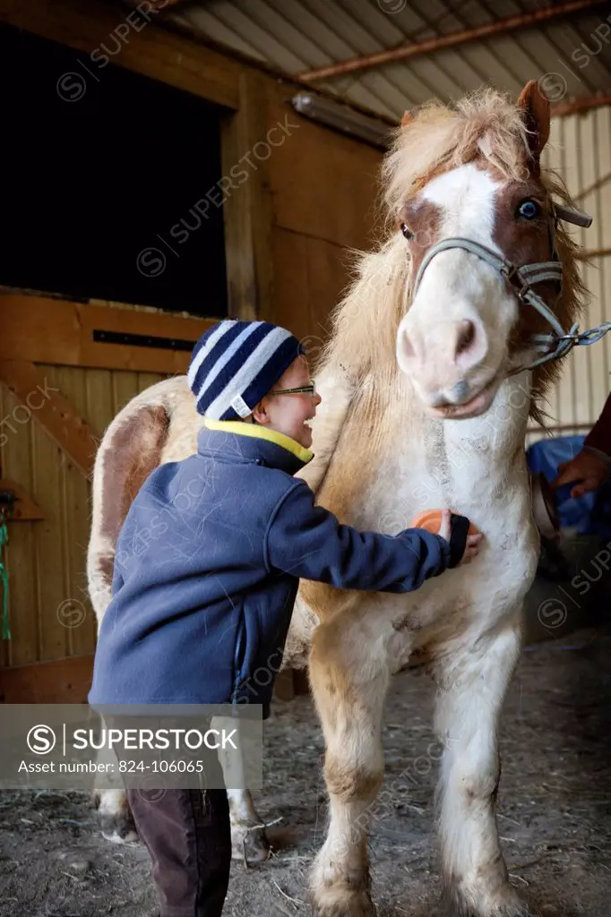 Photo essay at EQUISENS, a therapeutic riding centre in Asniere_les_Dijon France. Hippotherapy session with a child having autistic disorders.