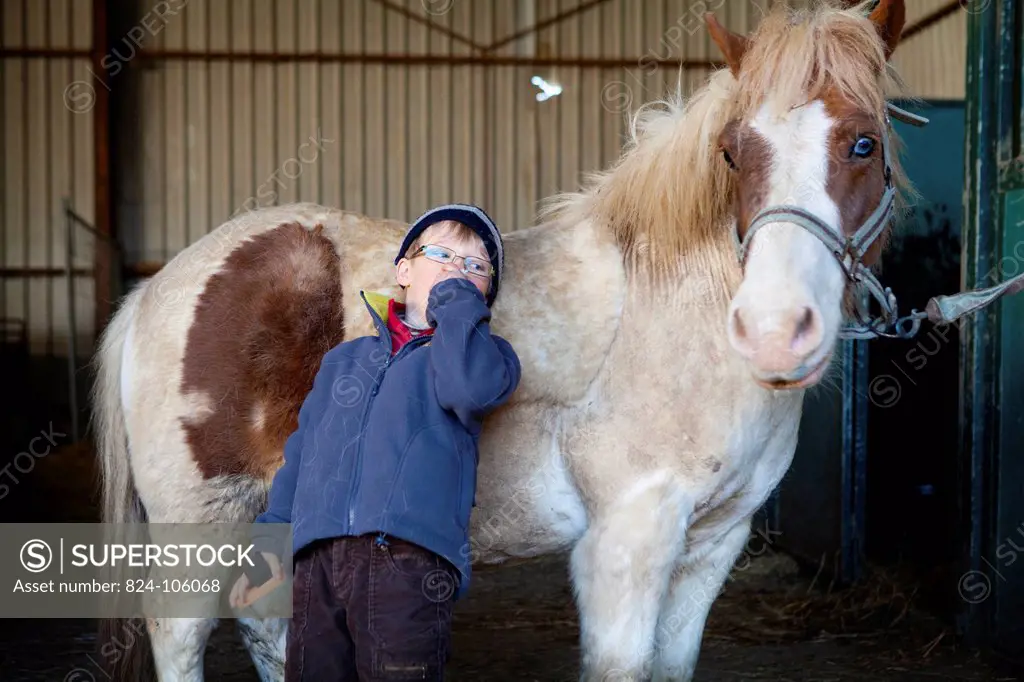 Photo essay at EQUISENS, a therapeutic riding centre in Asniere_les_Dijon France. Hippotherapy session with a child having autistic disorders.