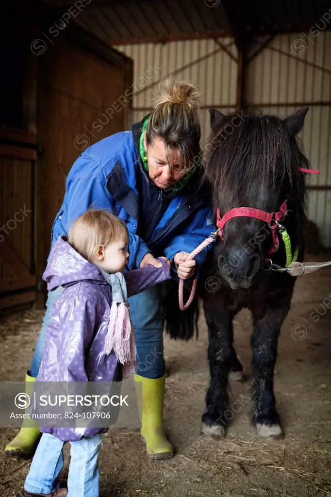 Photo essay at EQUISENS, a therapeutic riding centre in Asniere_les_Dijon France. Hippotherapy session with a child having autistic disorders and the ...