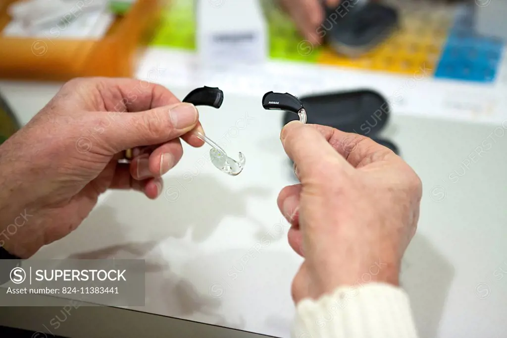 Reportage in an audio prosthesist practice. adjusting hearing aids.